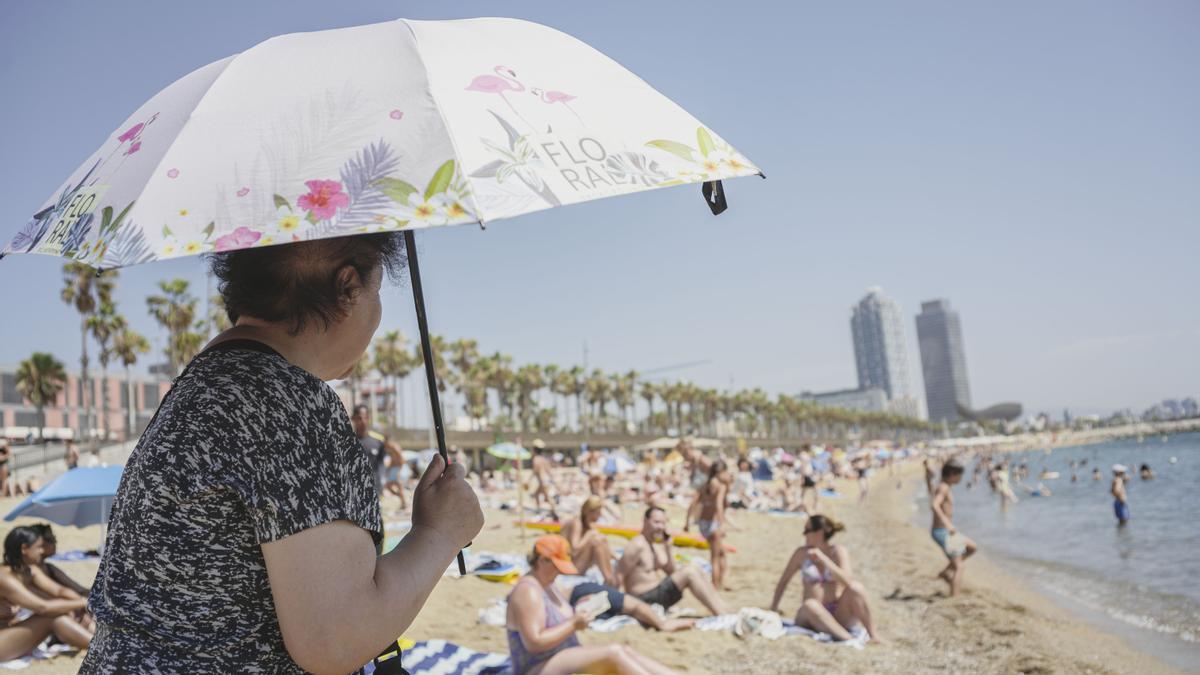 BARCELONA, 18 de julio de 2023: Un bañista se protege del sol en la playa de la Barceloneta. Meteocat y la AEMET han activado avisos en Catalunya debido a la llegada de una ola de calor. FOTO: Ángel García Martos