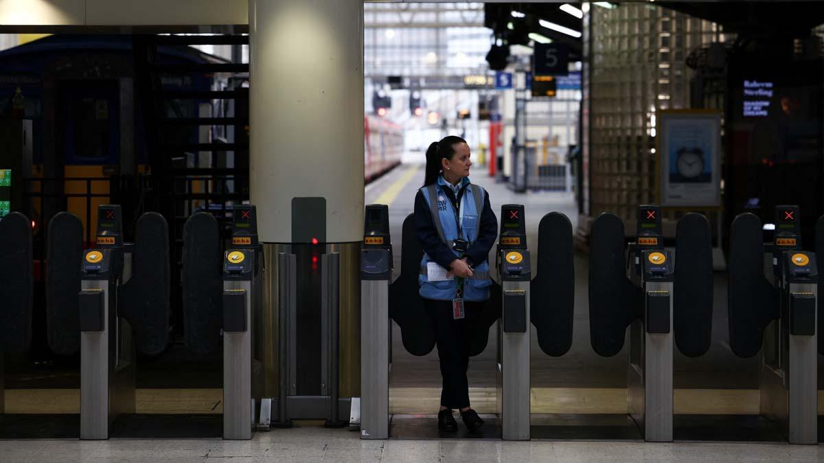 Un trabajador ferroviario se encuentra en las puertas dentro de la estación de Waterloo, en el tercer día de huelgas ferroviarias nacionales, en Londres, Gran Bretaña, el 23 de junio de 2022. REUTERS/Henry Nicholls