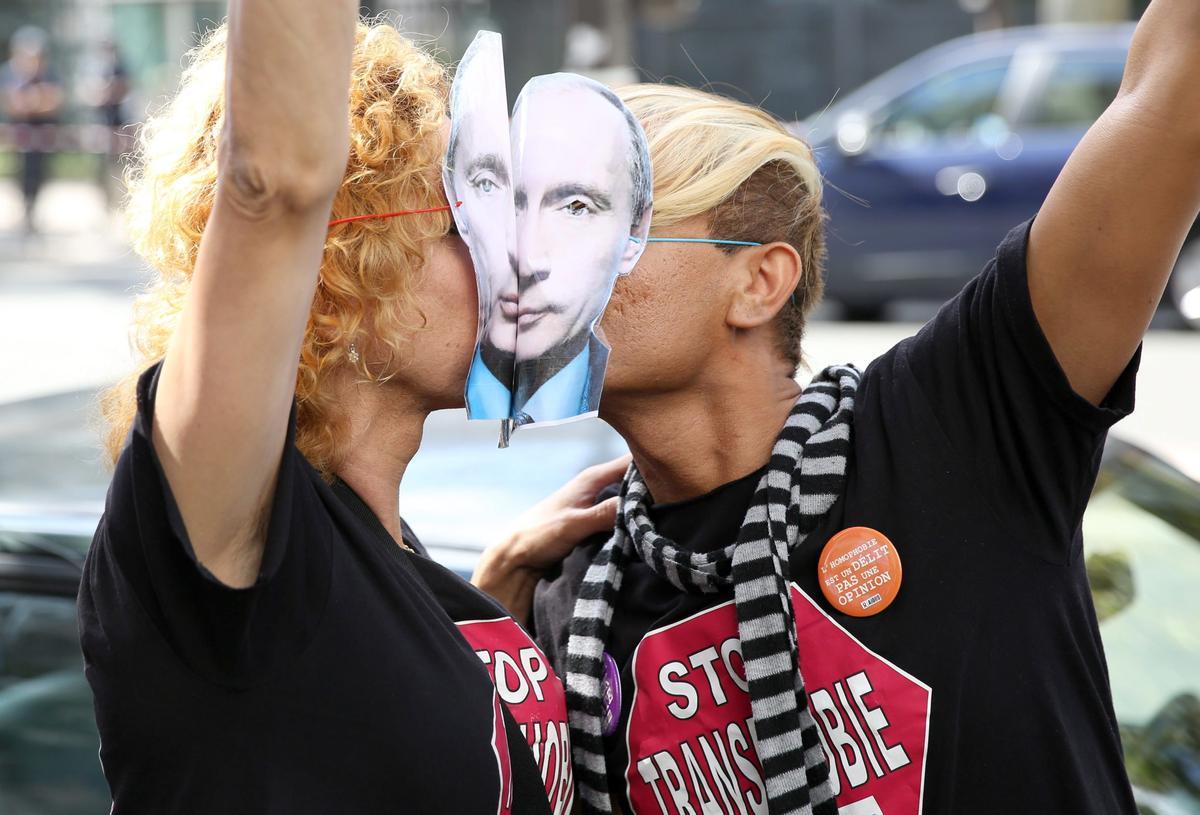 Dos personas se besan en Moscú con caretas de Putin.
