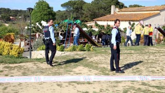 Agentes de los Mossos d'Esquadra en el jardín del restaurante de Caldes de Malavella donde murió ayer una niña.