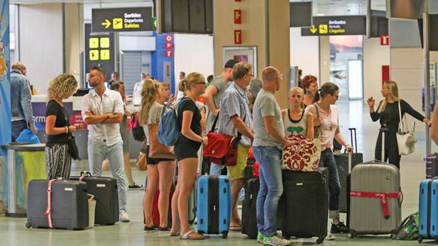 Un grupo de turistas hace cola en el aeropuerto de Ibiza.
