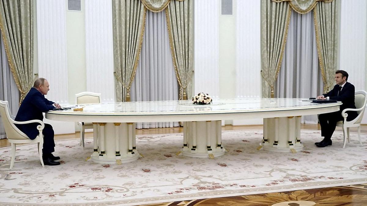 Putin y Macron, alejados entre sí por una mesa de dimensiones extraodinarias.