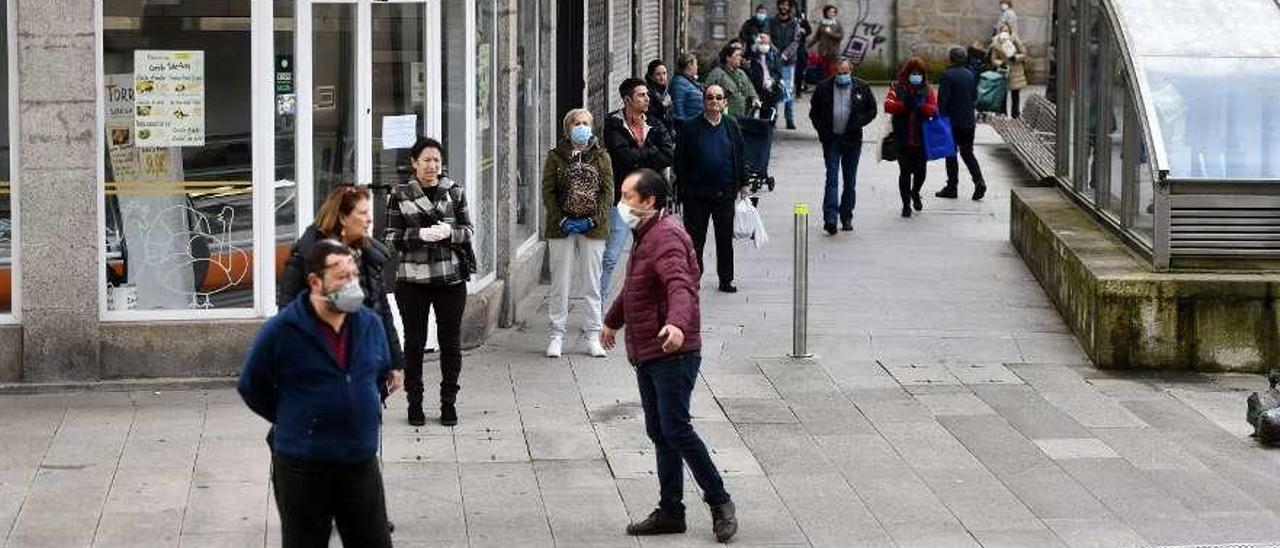 Arriba: una de las colas que se formó ante el Mercado durante la mañana de ayer. Id: piden una reorganización de la circulación en los puestos del interior. // G.S.