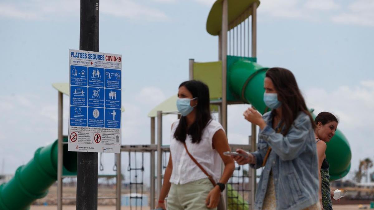 Dos mujeres pasean con mascarilla por el Paseo Marítimo de València.