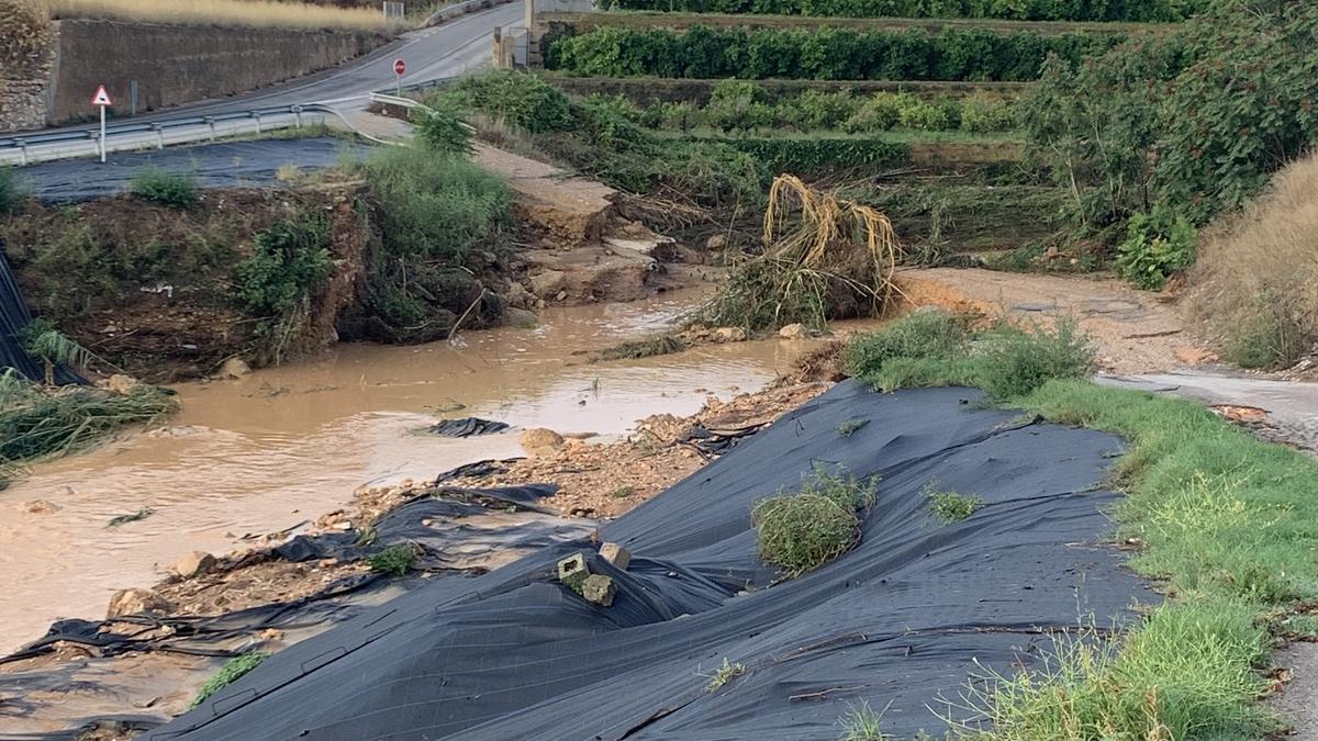 La tormenta desborda el barranc y destruye la pasarela del polígono de Vilamarxant