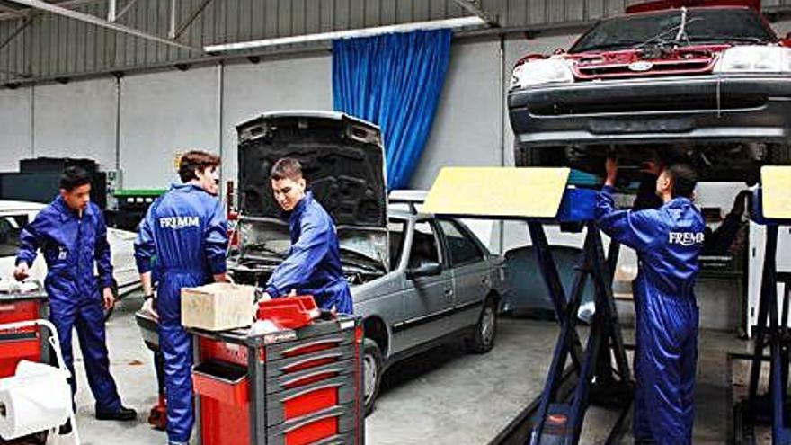 Varios operarios en un taller de reparación de vehículos.