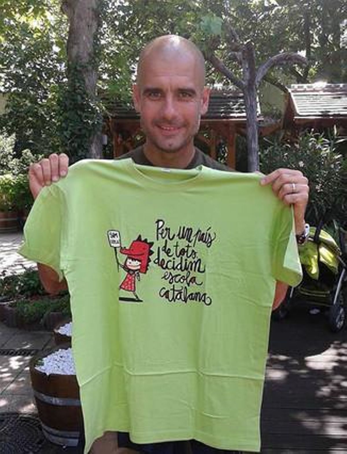 Pep Guardiola ensenya la samarreta en suport a l’escola catalana.