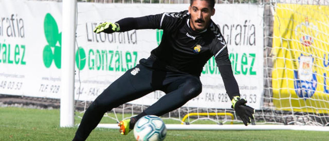 El sevillano Álvaro Valles, portero de la UD Las Palmas, realiza una estirada durante un entrenamiento en el campo David García de la ciudad deportiva de Barranco Seco.