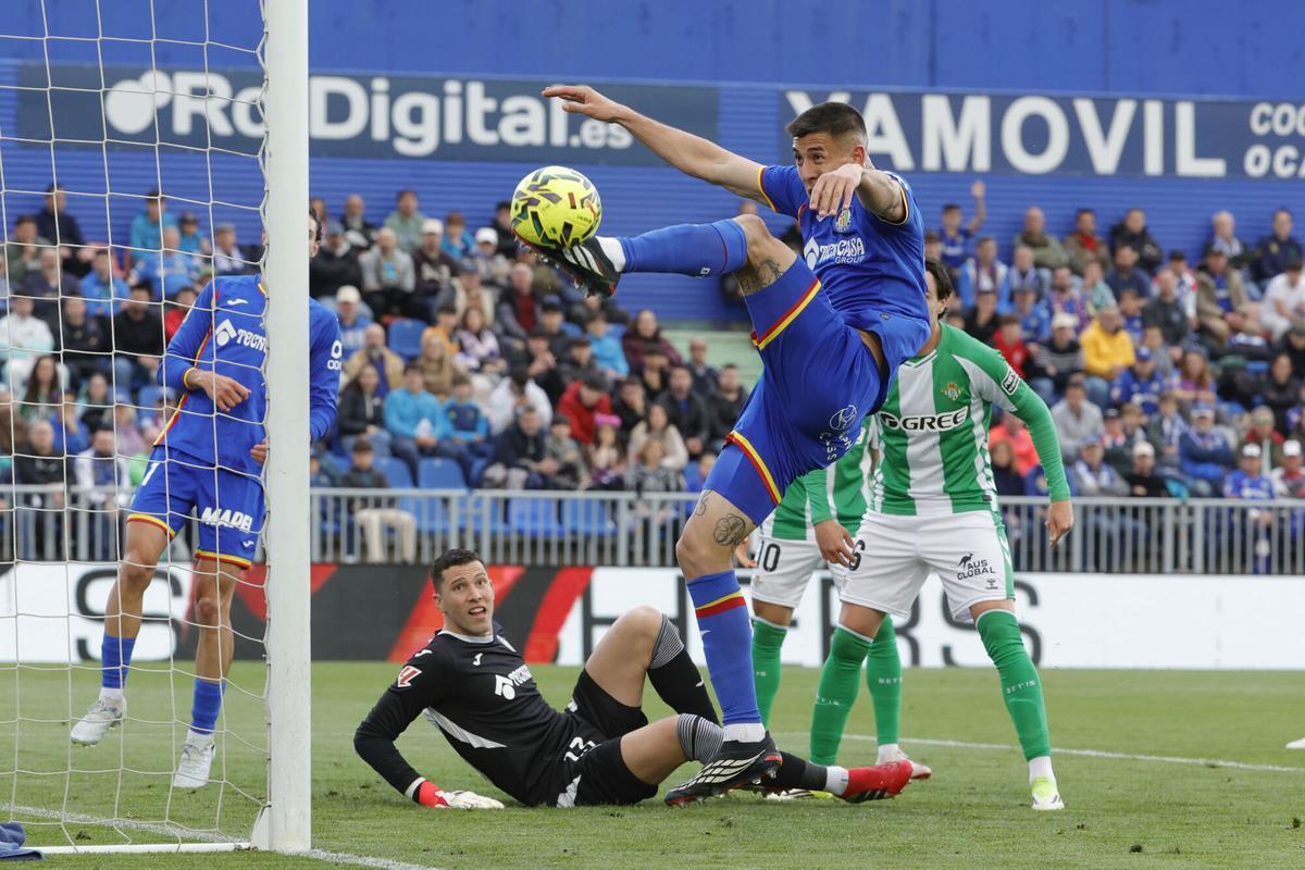 El defensa argentino del Getafe Zaid Romero (c) despeja un ataque.