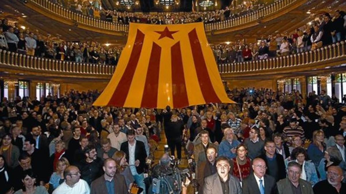 Militantes de ERC, con Joan Puigcercós en primera fila, despliegan una gran bandera independentista bajo los acordes de 'El cant de la senyera', ayer en el Palau de la Música.