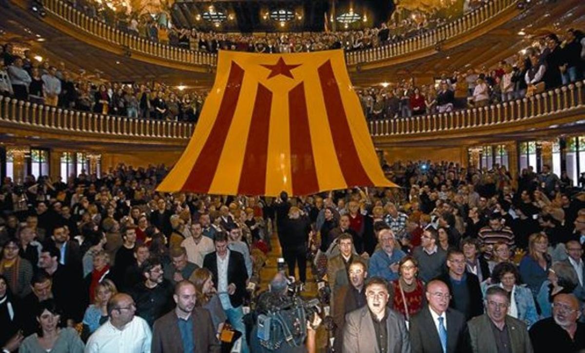 Militants d’ERC, amb Joan Puigcercós en primera fila, despleguen una gran bandera independentista sota els acords d’’El cant de la senyera’, ahir al Palau de la Música.