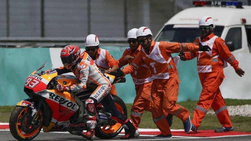 Marc Márquez levanta su moto tras una caída en los entrenamientos libres de Malasia.