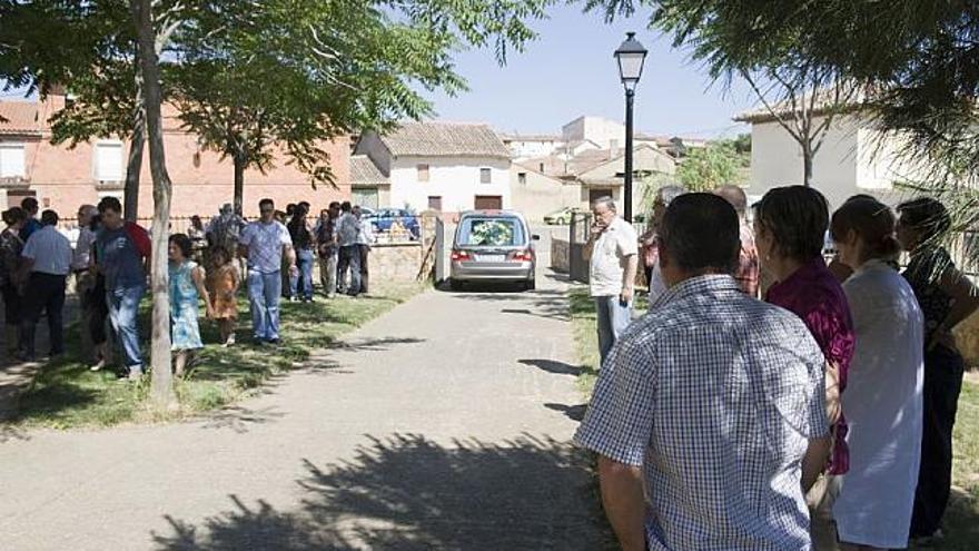 Trabjadores de Asprosub esperan la llegada del féretro a la igleisa de Vilabrázaro ayer por la tarde.