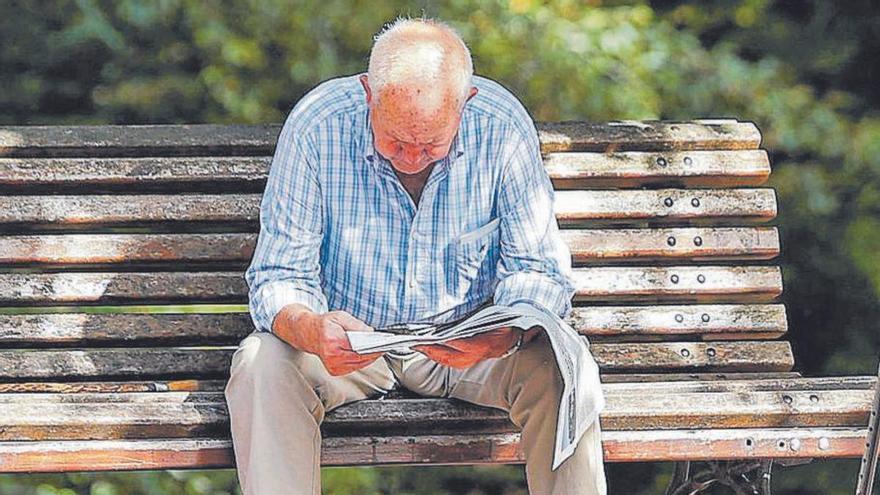 Un hombre de avanzada edad lee el periódico en un parque. | Efe