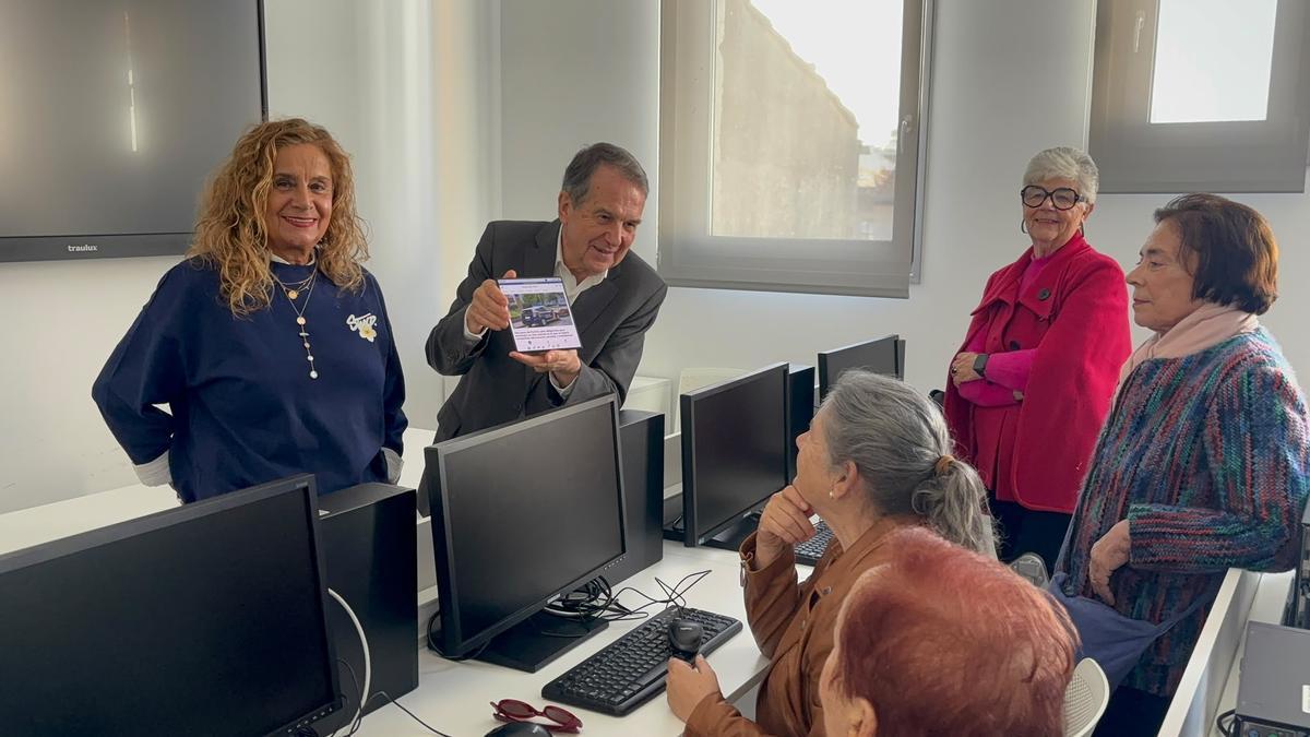 Abel Caballero, junto a Carmela Silva, enseña a las alumnas la versión digital de FARO en su teléfono.