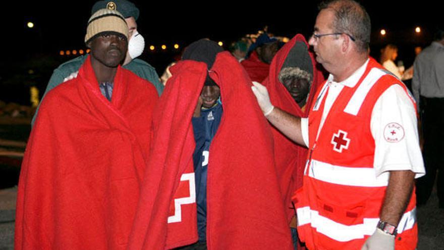 Efectivos de Cruz Roja acompañan a los 36 inmigrantes subsaharianos, todos ellos varones y mayores de edad, que han llegado al puerto de Motril