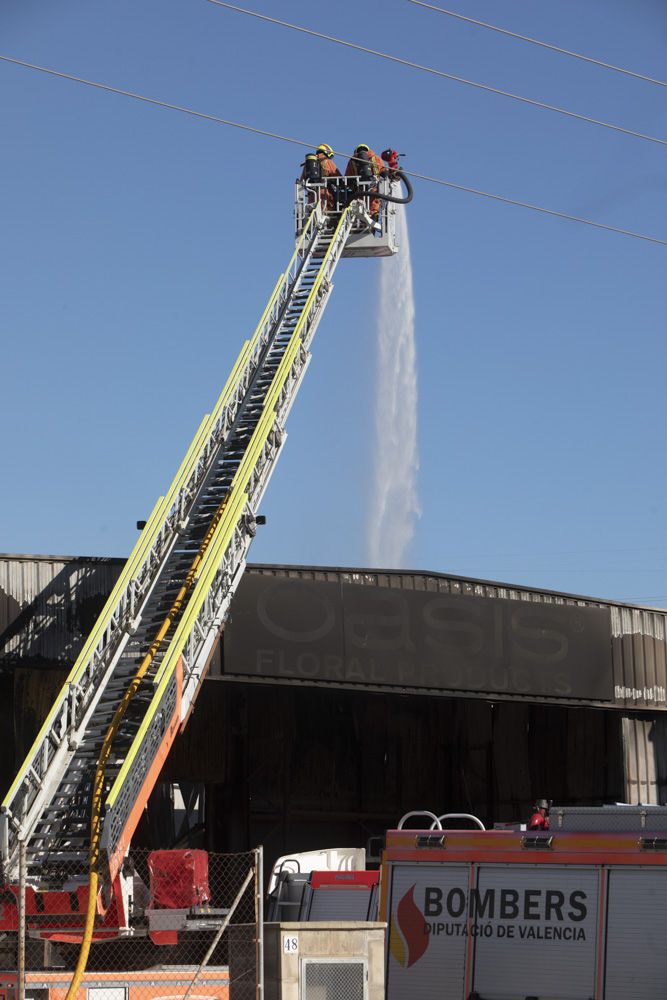 Los bomberos siguen trabajando en la nave del Port de Sagunt un día después del incendio