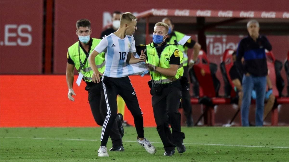 Miembros de seguridad del Visit Mallorca Estadio detienen al espontáneo.