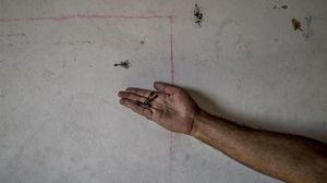 Un palestí del camp de refugiats de Bureij a la Franja de Gaza sosté a la palma de la mà alguns dards, com el que es veu a la paret de casa seva.