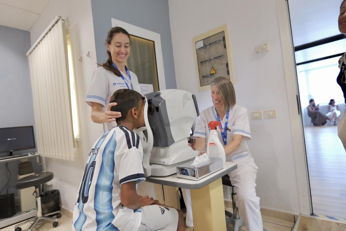 Un niño saharaui durante la revisión oftalmológica, junto a dos profesionales del centro.