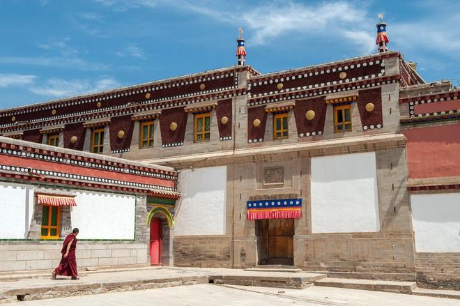 Monje tibetano camina por el monasterio budista de Kumbumi