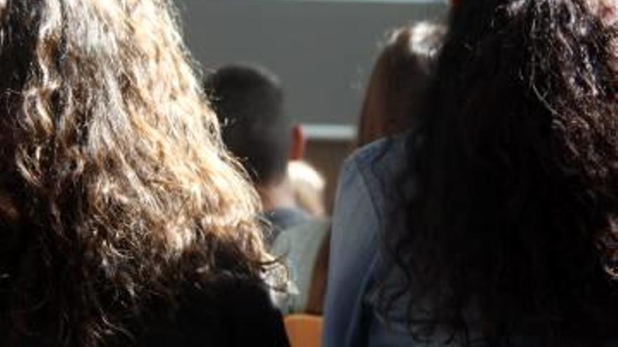 Dues menors, d&#039;esquena, en una aula d&#039;una escola.