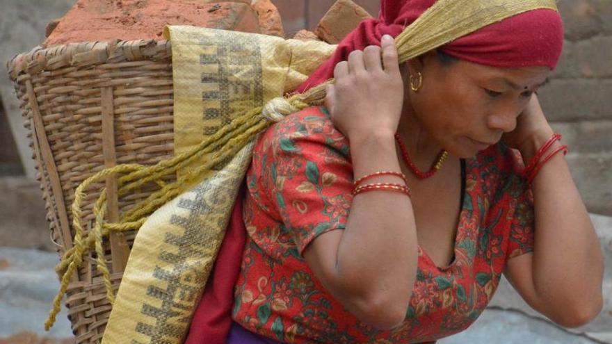 Una nepalí carga ladrillos.