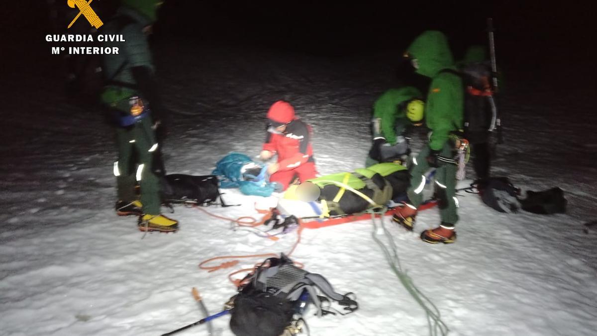 Los miembros del equipo de rescate, junto al montañero accidentado.