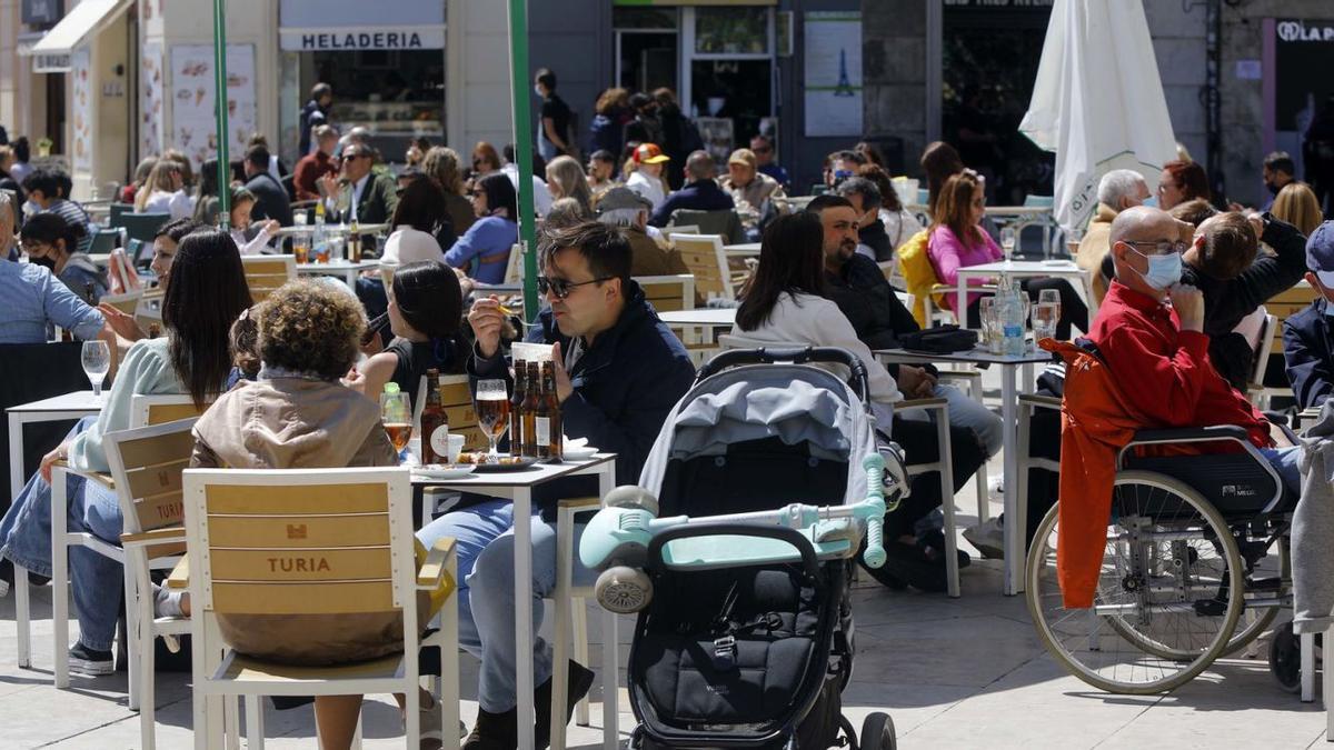 Decenas de personas sentadas en una terraza del centro de València mientras rige la obligación de disponer del pasaporte covid. | M.A.MONTESINOS