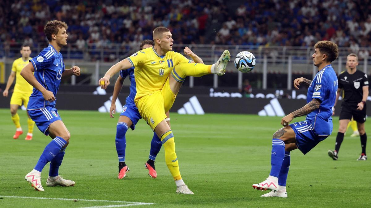 Dovbyk ataca un balón rodeado de defensas italianos en la fase de clasificación.