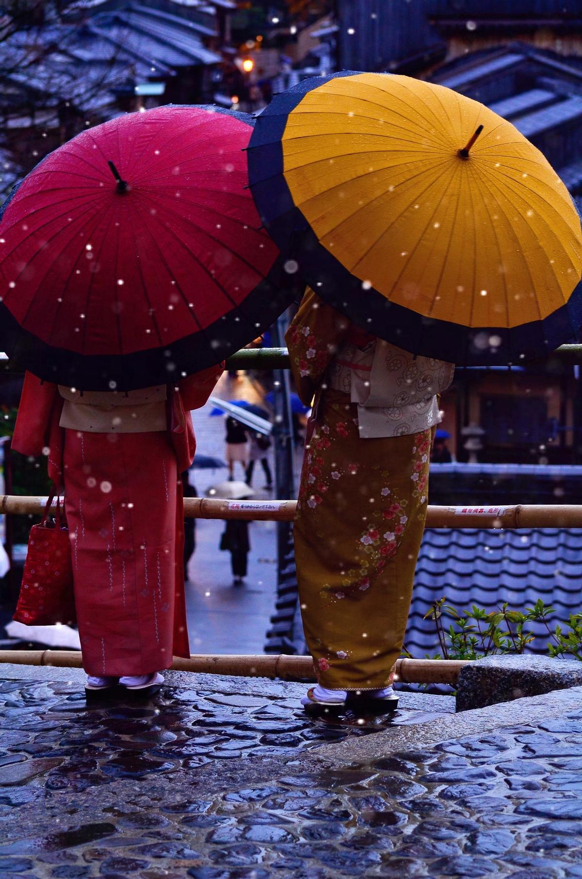 Dos mujeres de espalda observan una calle de Kioto cuando el fotógrafo se percata de su presencia y toma una imagen espontánea.
