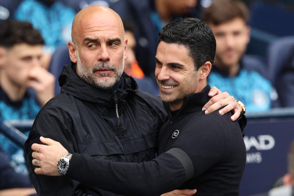 (FILES) Manchester City's Spanish manager Pep Guardiola (L) embraces Arsenal's Spanish manager Mikel Arteta before the start of the English Premier League football match between Manchester City and Arsenal at the Etihad Stadium in Manchester, north west England, on April 19, 2026. Arsenal ended a 22-year wait to be crowned Premier League champions on May 19, 2026, after Manchester City were defeated in their match against Bournemouth. (Photo by Darren Staples / AFP) / RESTRICTED TO EDITORIAL USE. No use with unauthorized audio, video, data, fixture lists, club/league logos or 'live' services. Online in-match use limited to 120 images. An additional 40 images may be used in extra time. No video emulation. Social media in-match use limited to 120 images. An additional 40 images may be used in extra time. No use in betting publications, games or single club/league/player publications. /. SEE CAPTION FOR MORE INFORMATION / RESTRICTED TO EDITORIAL USE. No use with unauthorized audio, video, data, fixture lists, club/league logos or 'live' services. Online in-match use limited to 120 images. An additional 40 images may be used in extra time