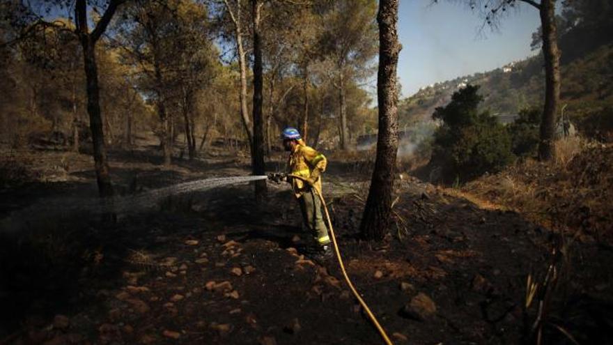 Un bombero extinguiendo el incendio cerca de Mijas