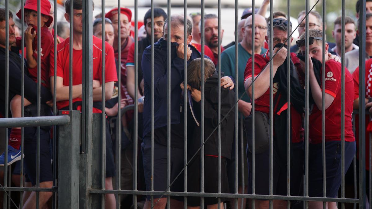 Aficionados del Liverpool se protegen del gas pimienta lanzado por la policía francesa en la final de la Champions entre Liverpool y Real Madrid.