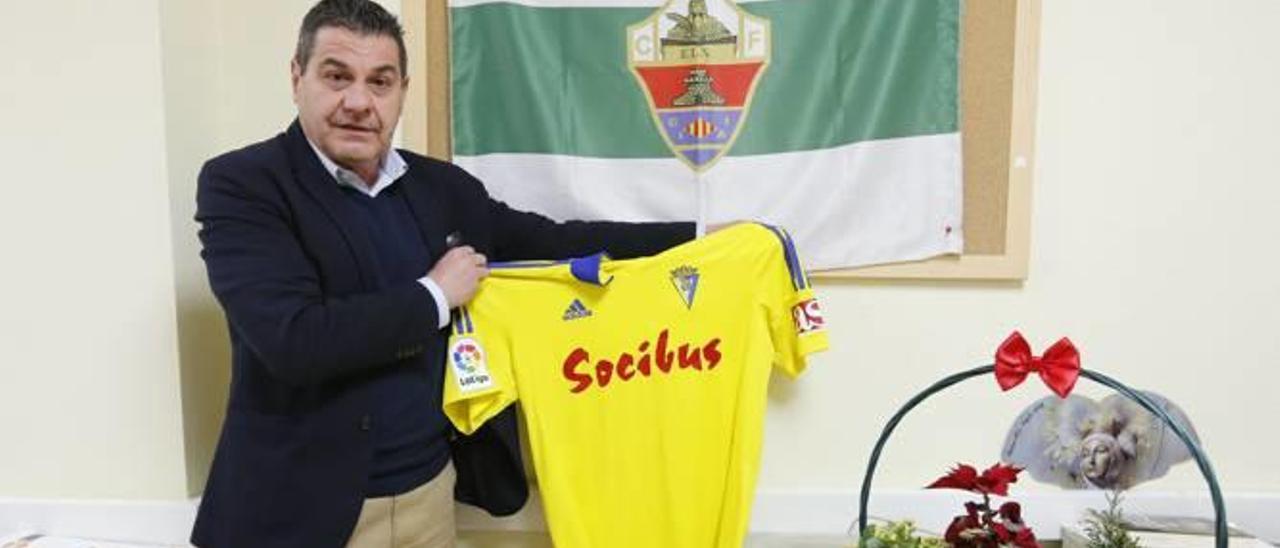 Paco López, ayer, en el diario INFORMACIÓN, junto a una bandera del Elche y con una camiseta del Cádiz (La de Aridame).