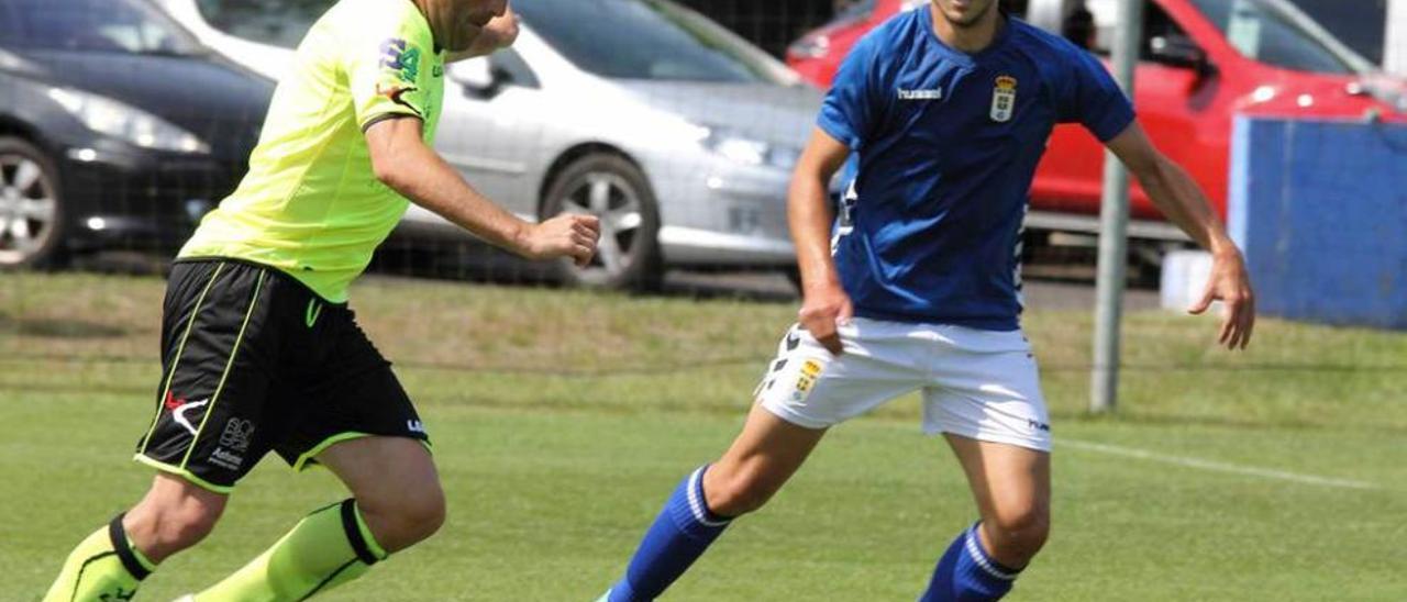 El jugador del Lealtad Sergio Villanueva, a la izquierda, ante Lucas, del Oviedo B.