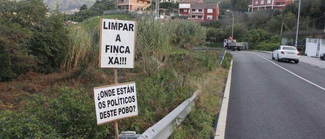 Los carteles colocados por los vecinos en la finca, con frente a la PO-315. // Santos Álvarez