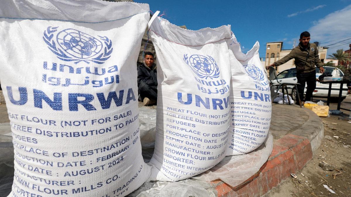 Desplazados palestinos aguardan para recibir ayuda de la UNRWA en Rafah.
