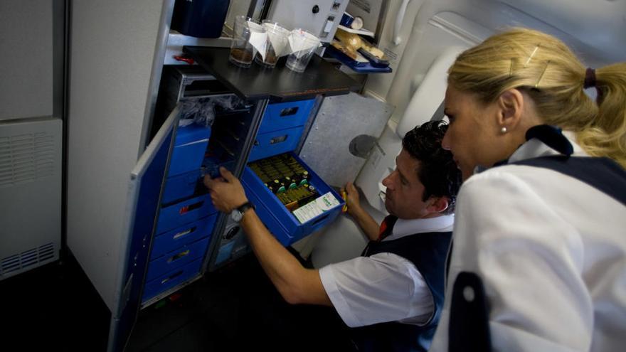 Dos tripulantes de cabina en el interior de un avión.