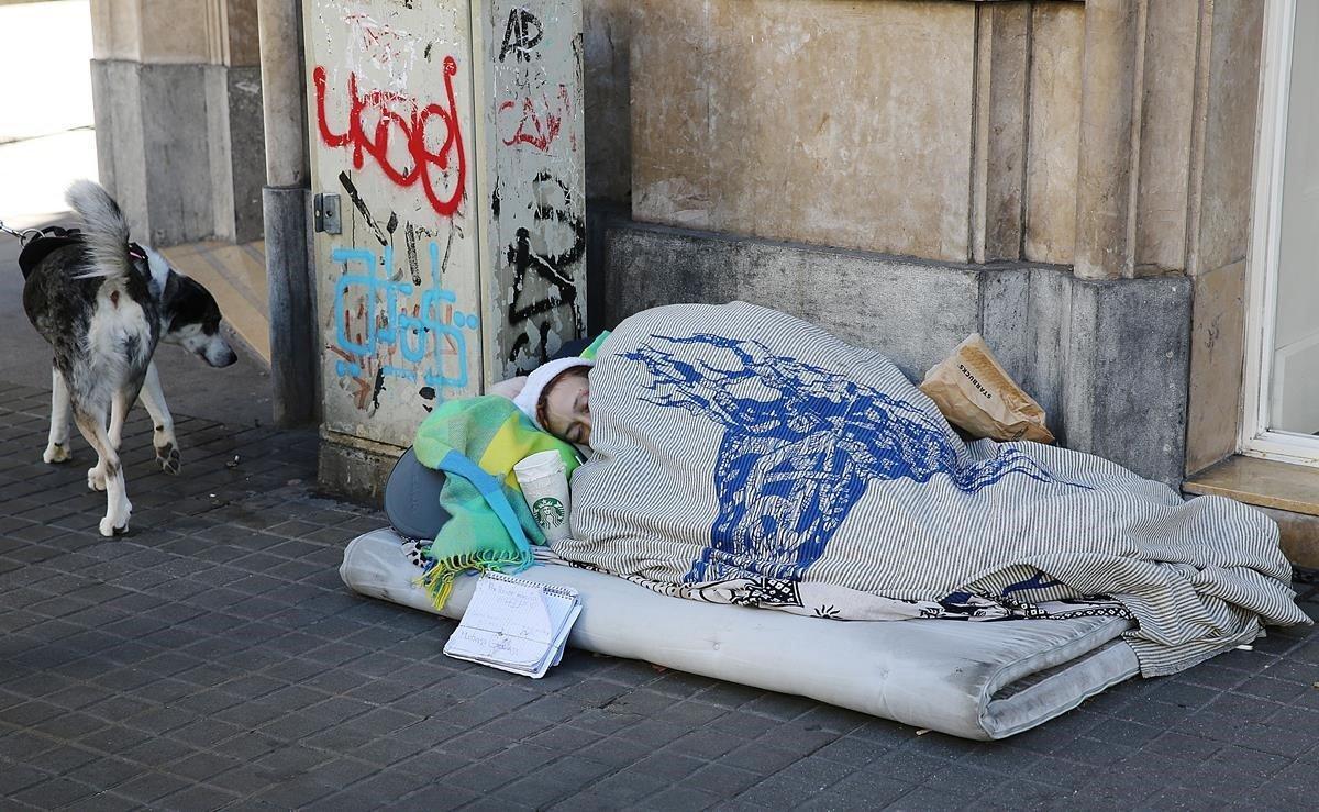 Una persona sin hogar, durmiendo a la intemperie en una calle de Barcelona, tras una de las noches más frías del presente año.