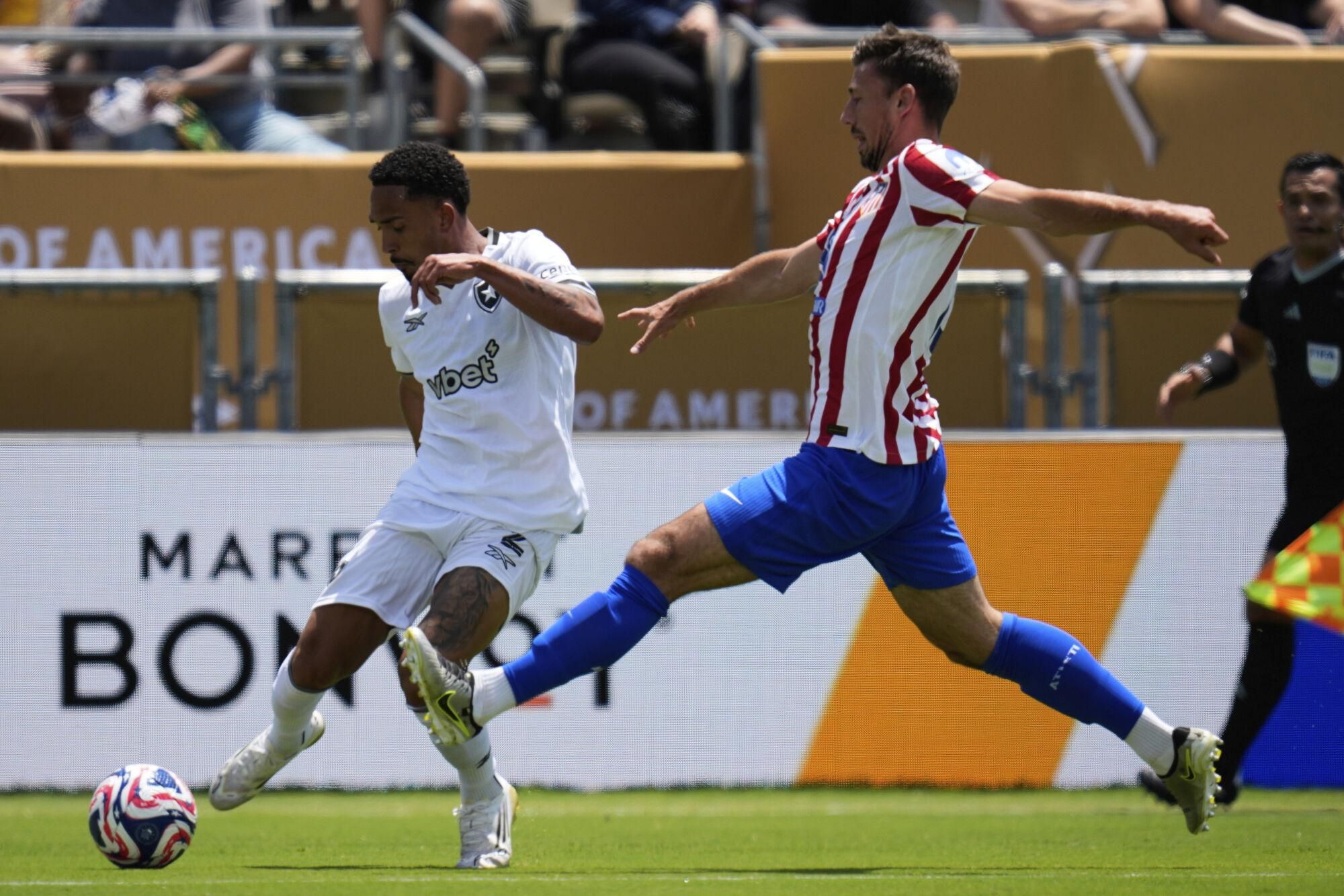 Botafogo's Vitinho, left, and Atletico Madrid's Clement Lenglet battle for the ball during the Club World Cup Group B soccer match between Atletico Madrid and Botafogo in Pasadena, Calif., Monday, June 23, 2025. (AP Photo/Greg Bull). EDITORIAL USE ONLY/ONLY ITALY AND SPAIN