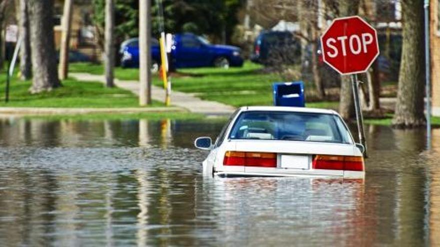 Un coche es arrastrado durante una inundación.