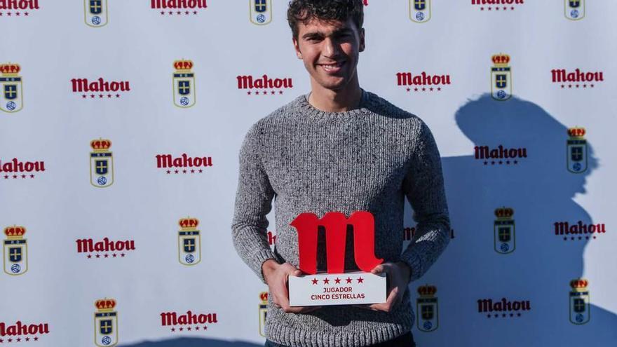 Arriba, Torró conduce el balón ante David Álvarez. Abajo, con el premio como mejor futbolista azul de diciembre.