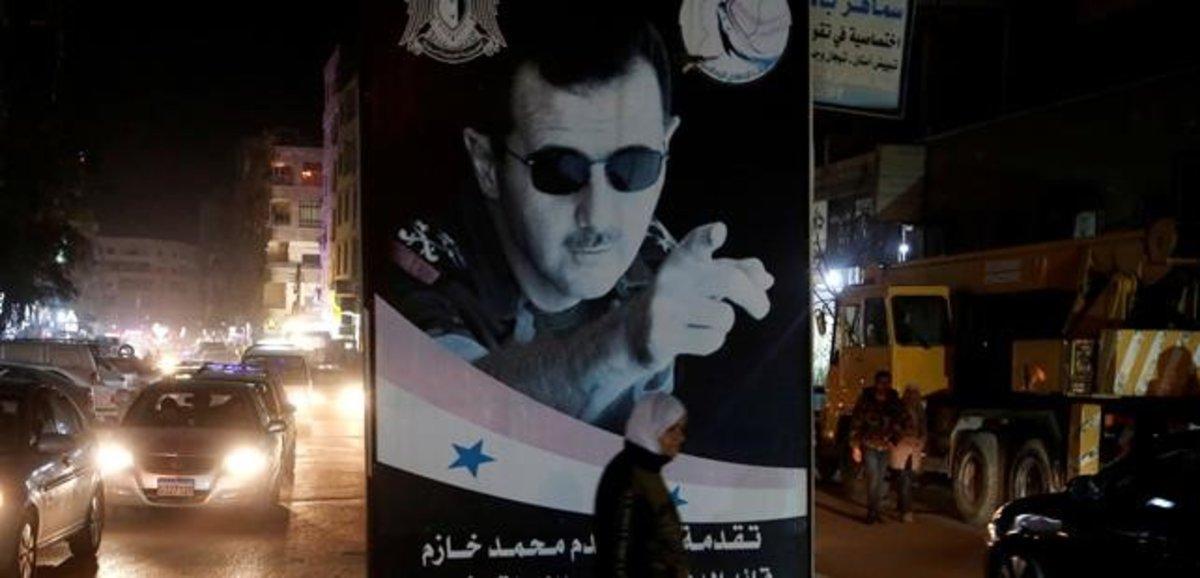Una mujer pasa ante un poster del presidente sirio, Bashar al-Assad, en Damasco.
