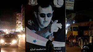 Una mujer pasa ante un poster del presidente sirio, Bashar al-Assad, en Damasco.