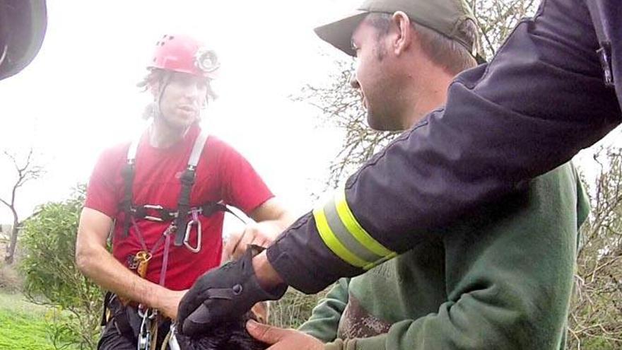 El perro con un bombero y uno de los cazadores.