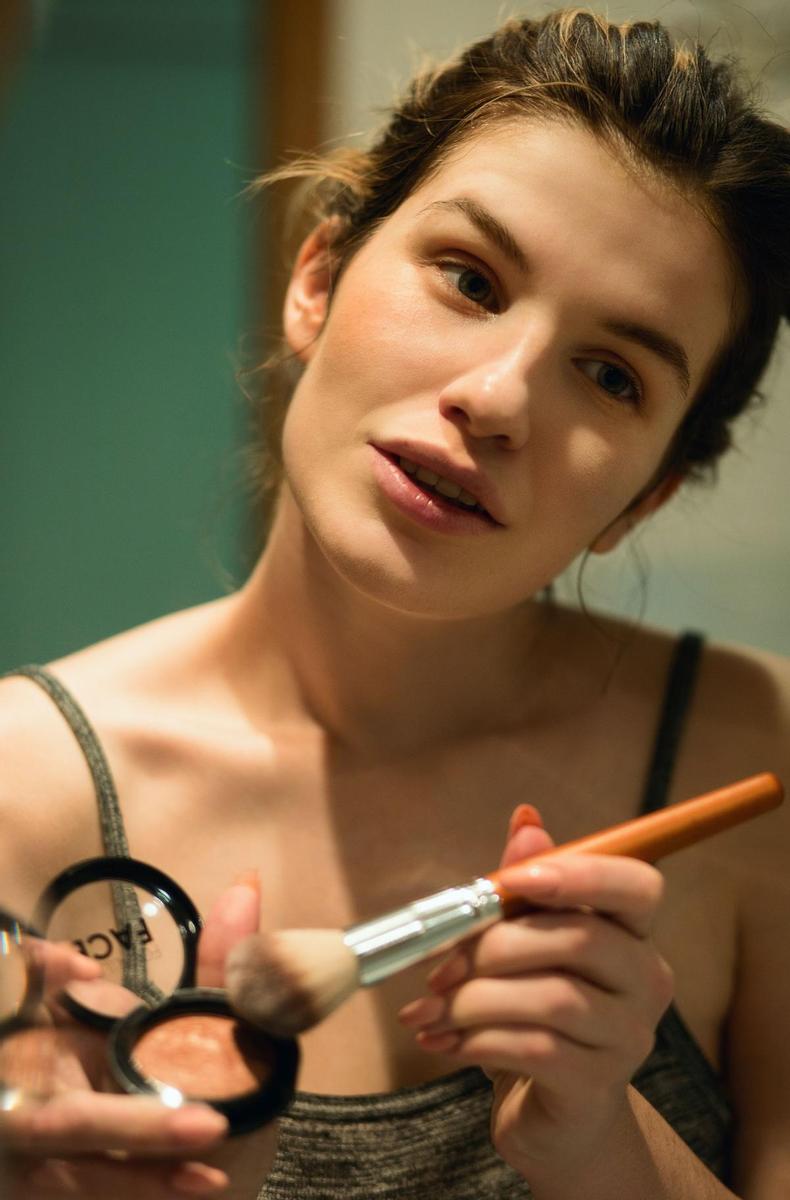 Mujer aplicándose la brocha de maquillaje