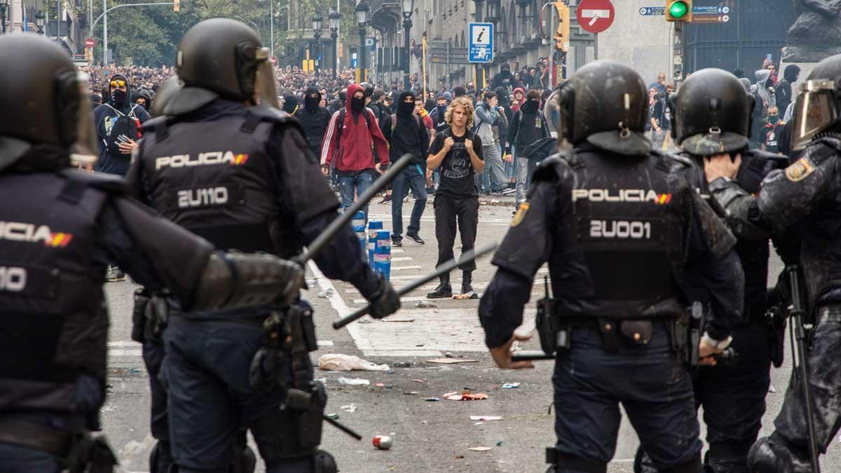 Un policía nacional graba los disturbios desde la furgoneta en Barcelona.