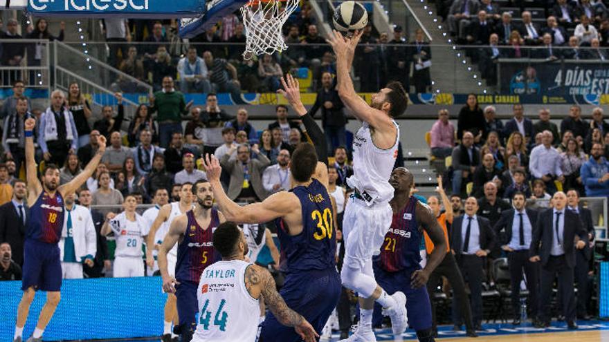 Rudy Fernández, alero del Real Madrid, intenta anotar en la última jugada de la final de Copa del Rey ante la mirada atenta de jugadores y aficionados.