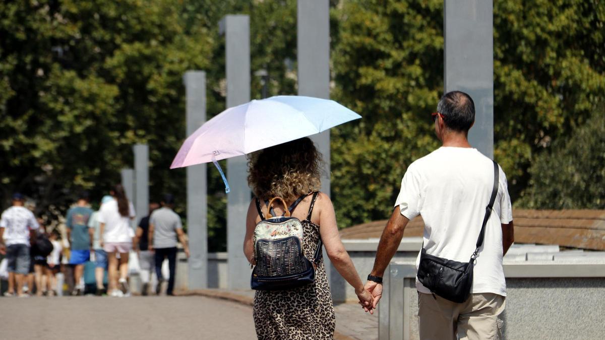 Una dona es protegeix del sol amb un paraigua